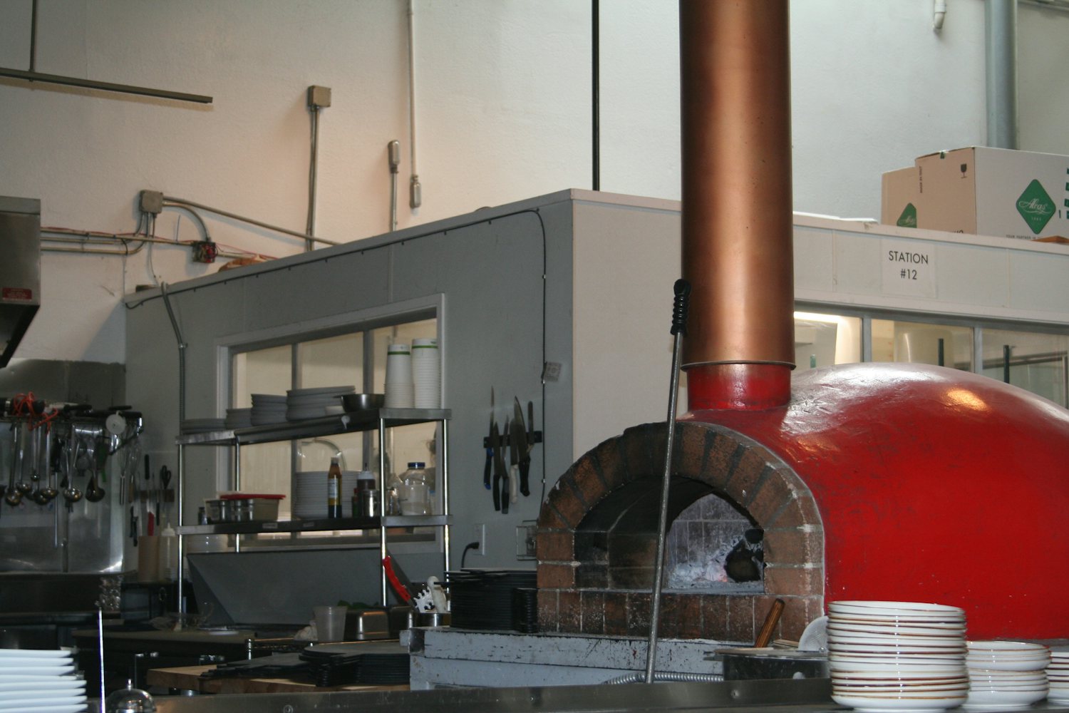Commercial kitchen with a brick oven and stainless prep line, a common rat pressure point